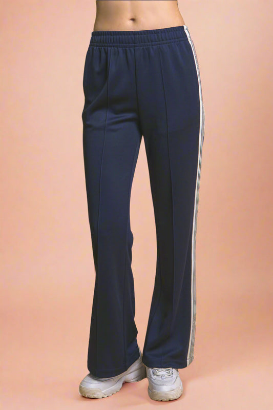 Navy blue pants with a white stripe on a mustard yellow background