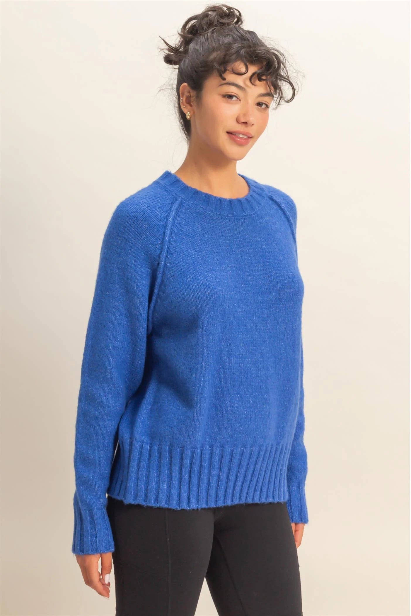 Woman wearing a blue sweater against a plain background