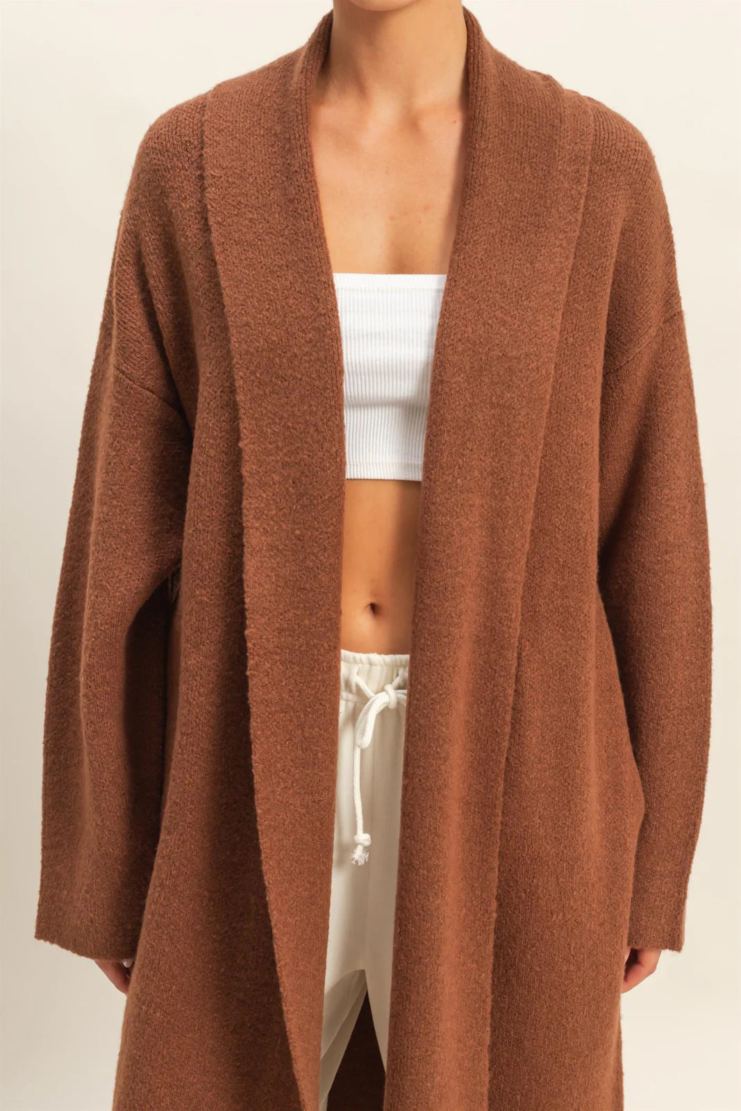 Brown cardigan worn by a person on a beige background