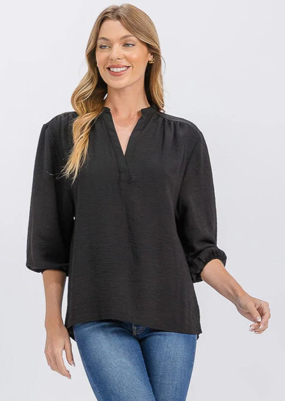 Woman wearing a black blouse and blue jeans on a white background
