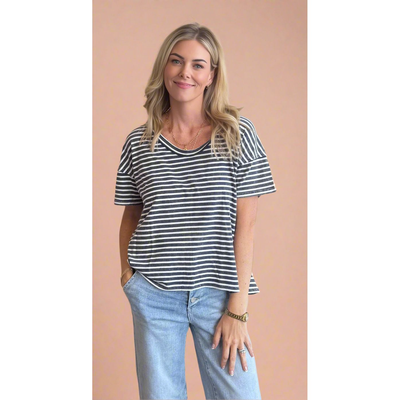 Woman wearing a striped shirt and jeans against a beige background