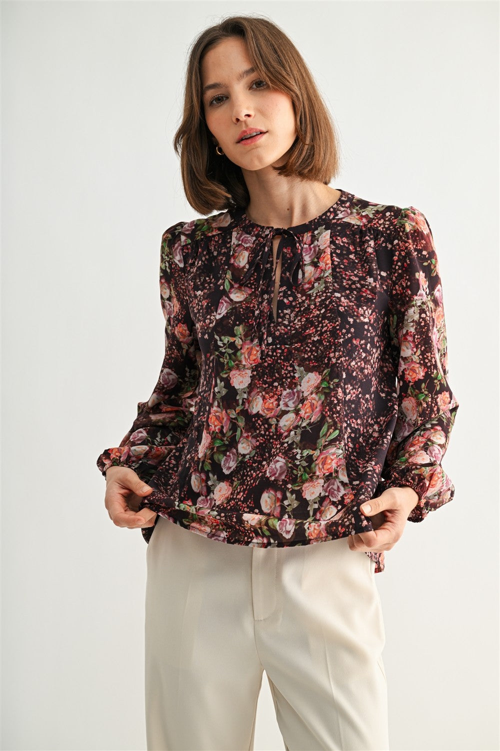 Woman wearing a floral blouse with a plain background