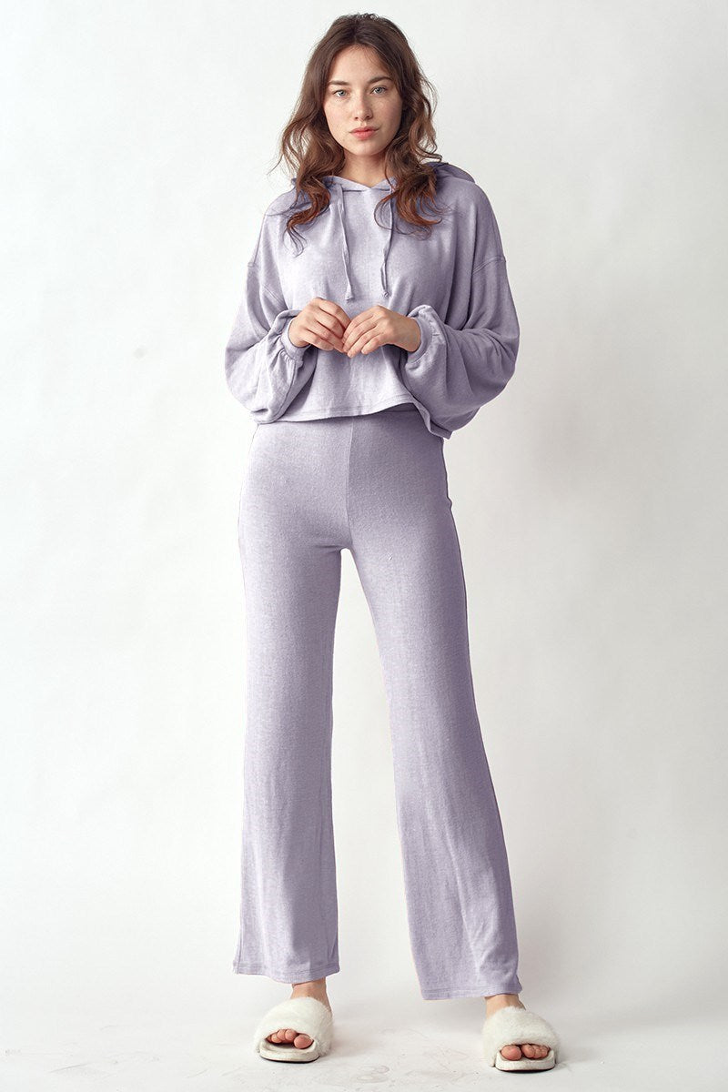 Woman wearing a light purple hoodie and pants on a white background
