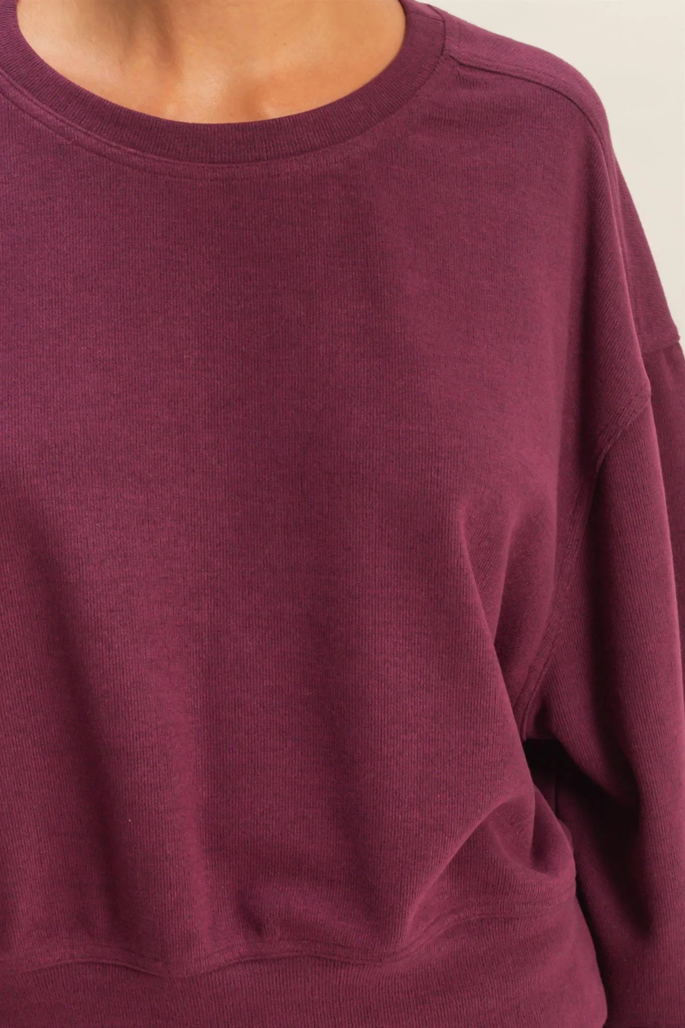 Close-up of a dark cherry sweatshirt worn by a person