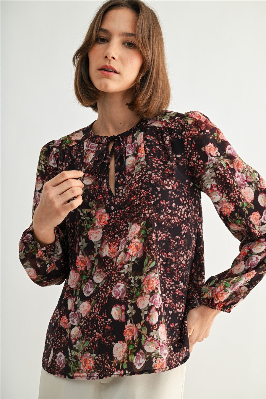Woman wearing a floral blouse against a white background