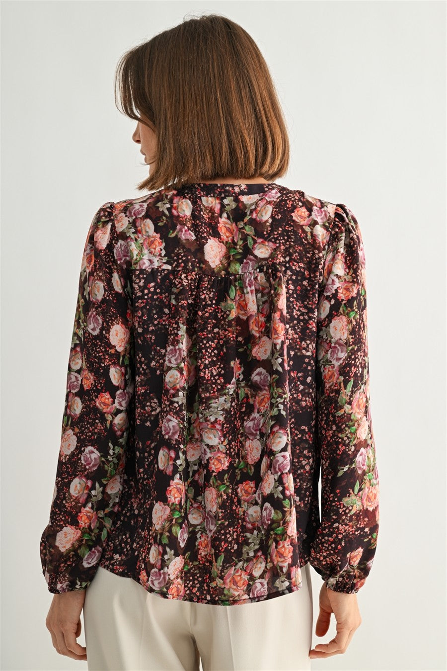 Woman wearing a floral blouse with a white background