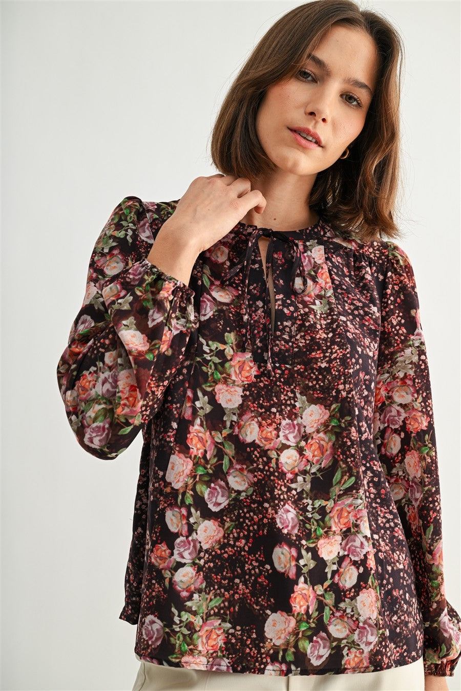Woman wearing a floral blouse against a white background
