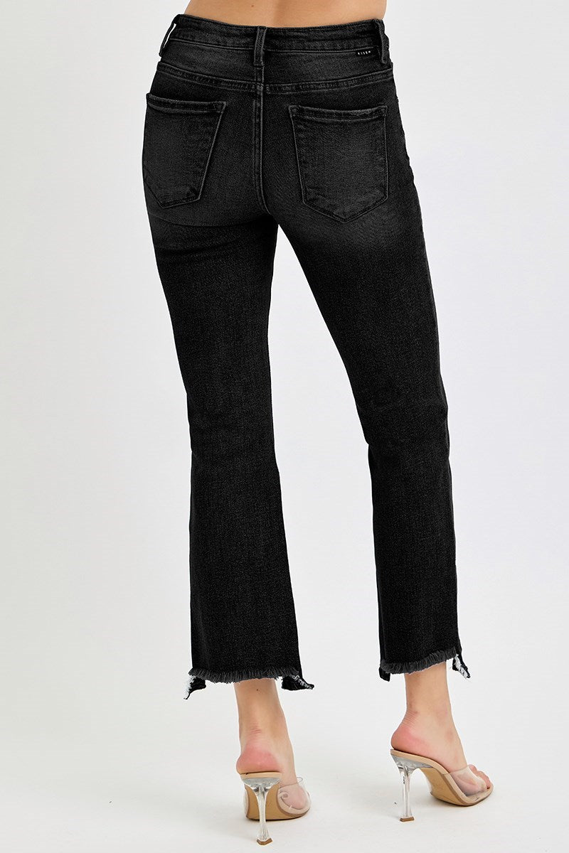 Black jeans worn by a person on a white background
