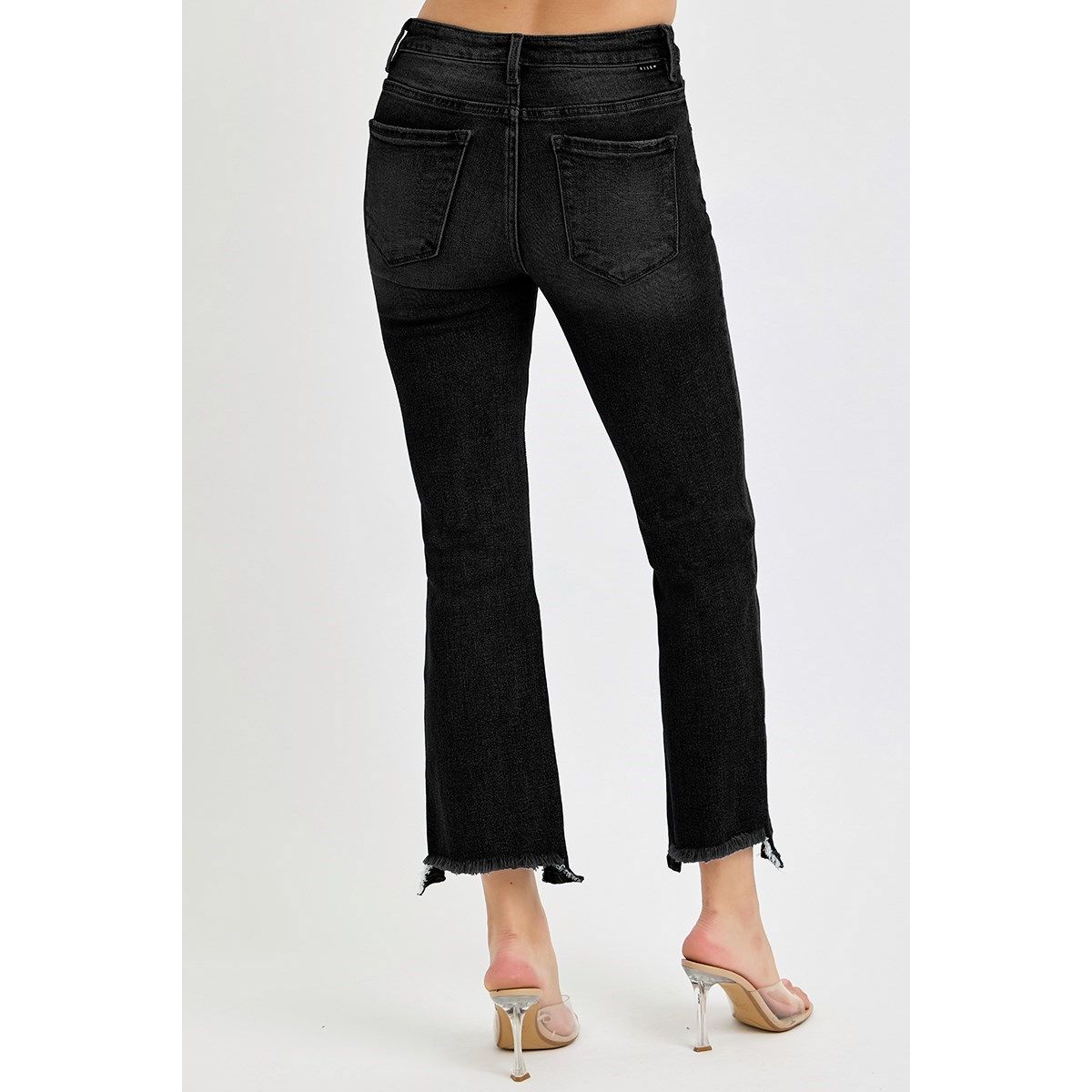 Black jeans worn by a person on a white background