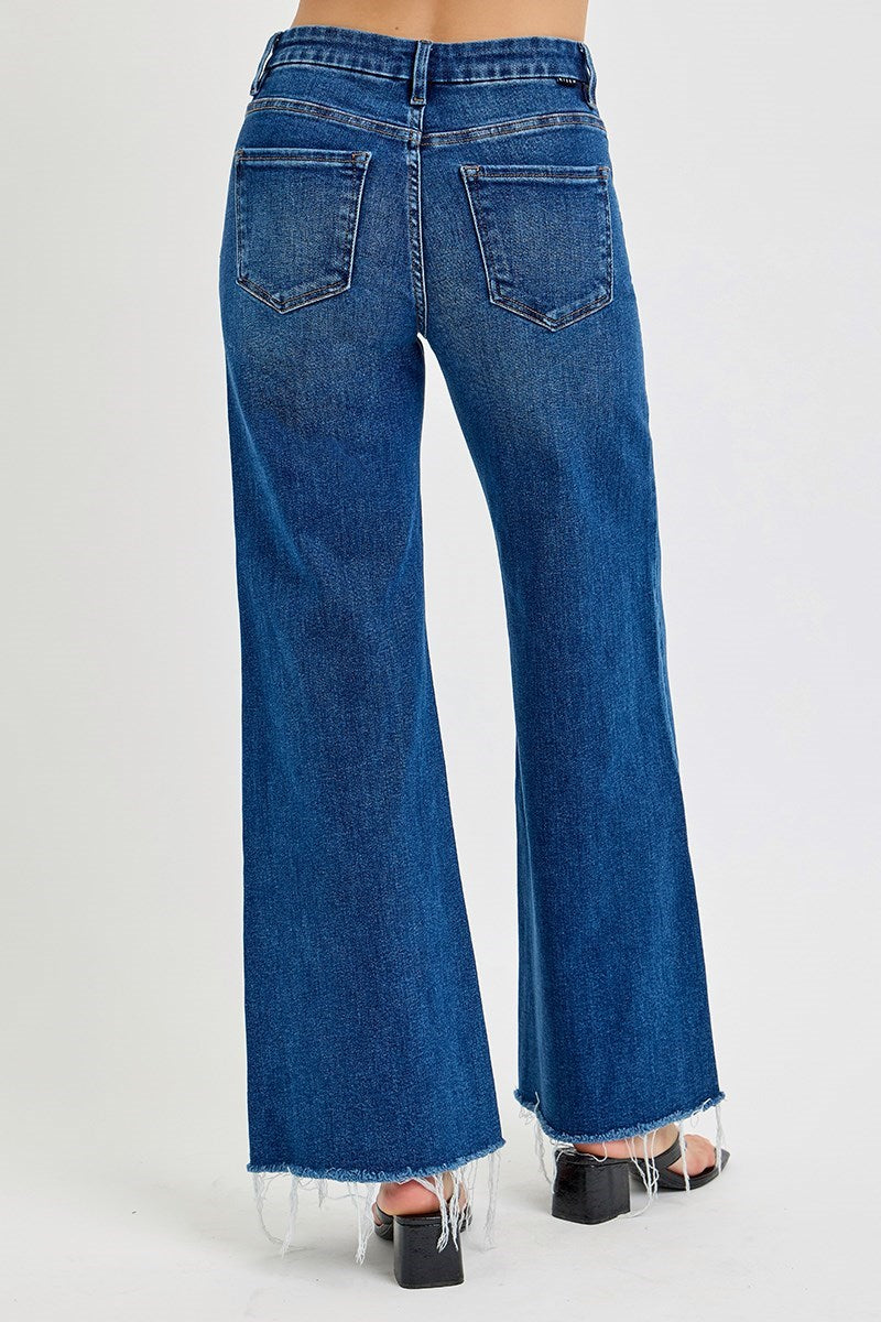 a person wearing Risen Poppy Blue jeans with black chunk heel sandals on a white background