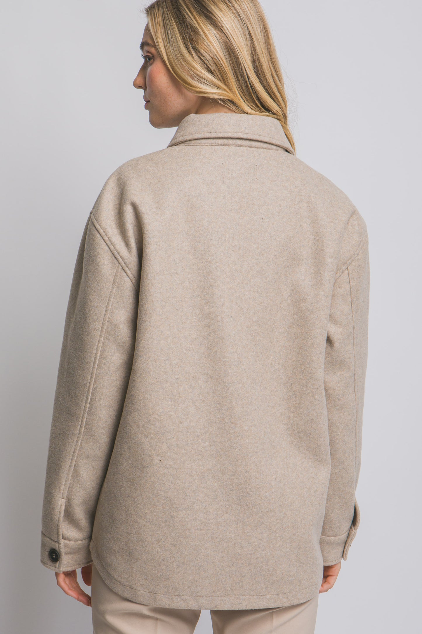 Beige jacket worn by a person on a plain background