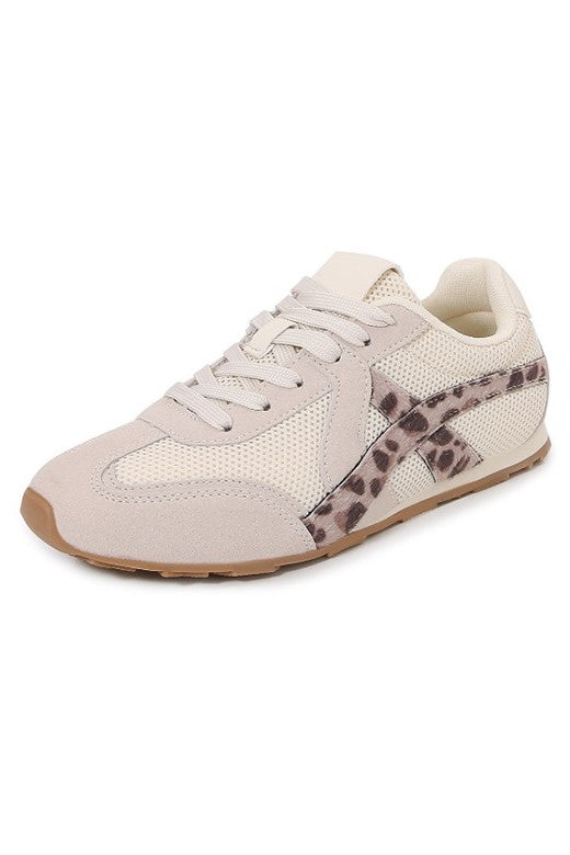 Beige sneaker with leopard print accents on a white background