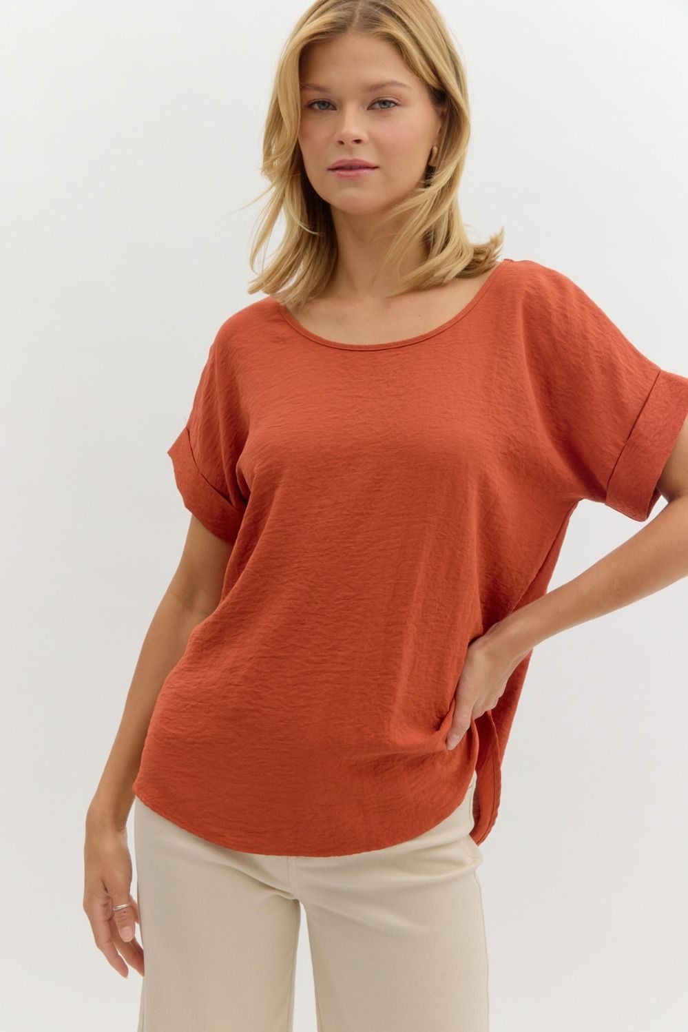 Woman wearing a rust-colored oversized shirt on a white background