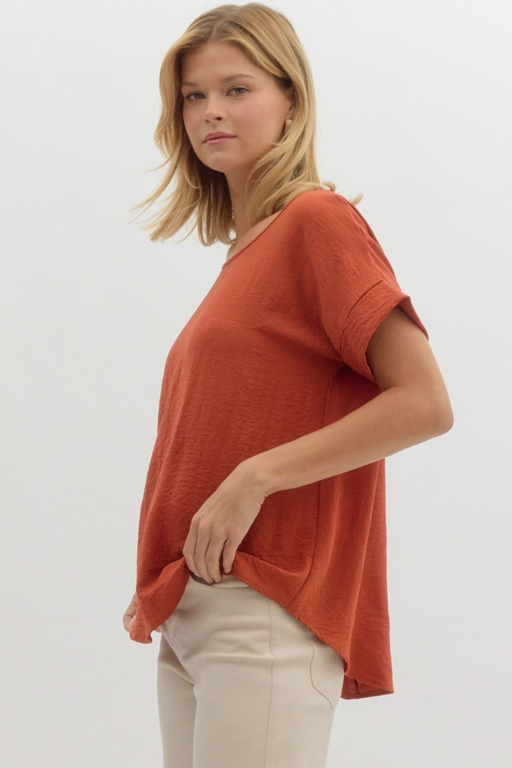 Woman wearing a rust-colored t-shirt on a white background
