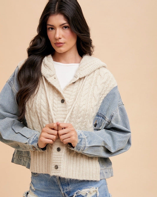 Woman wearing a layered outfit with a knit cardigan, denim jacket, and shorts on a beige background
