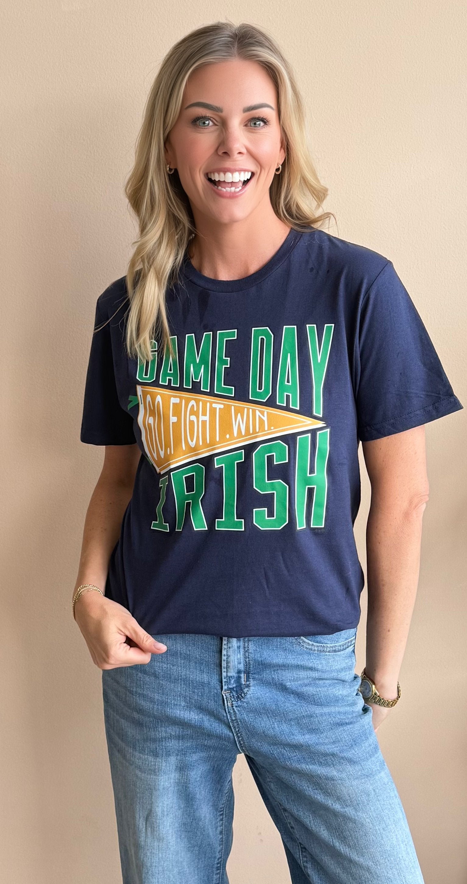 Woman wearing a navy blue t-shirt with 'Game Day Go Fight Win Irish' text on a beige background