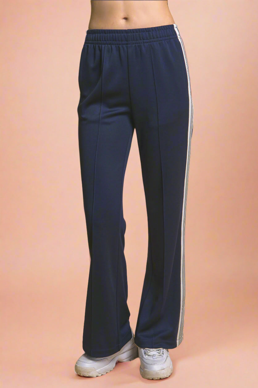 Navy blue pants with a white stripe on a mustard yellow background