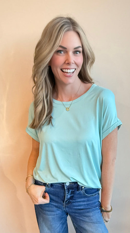 Woman wearing a light blue t-shirt and jeans against a beige background