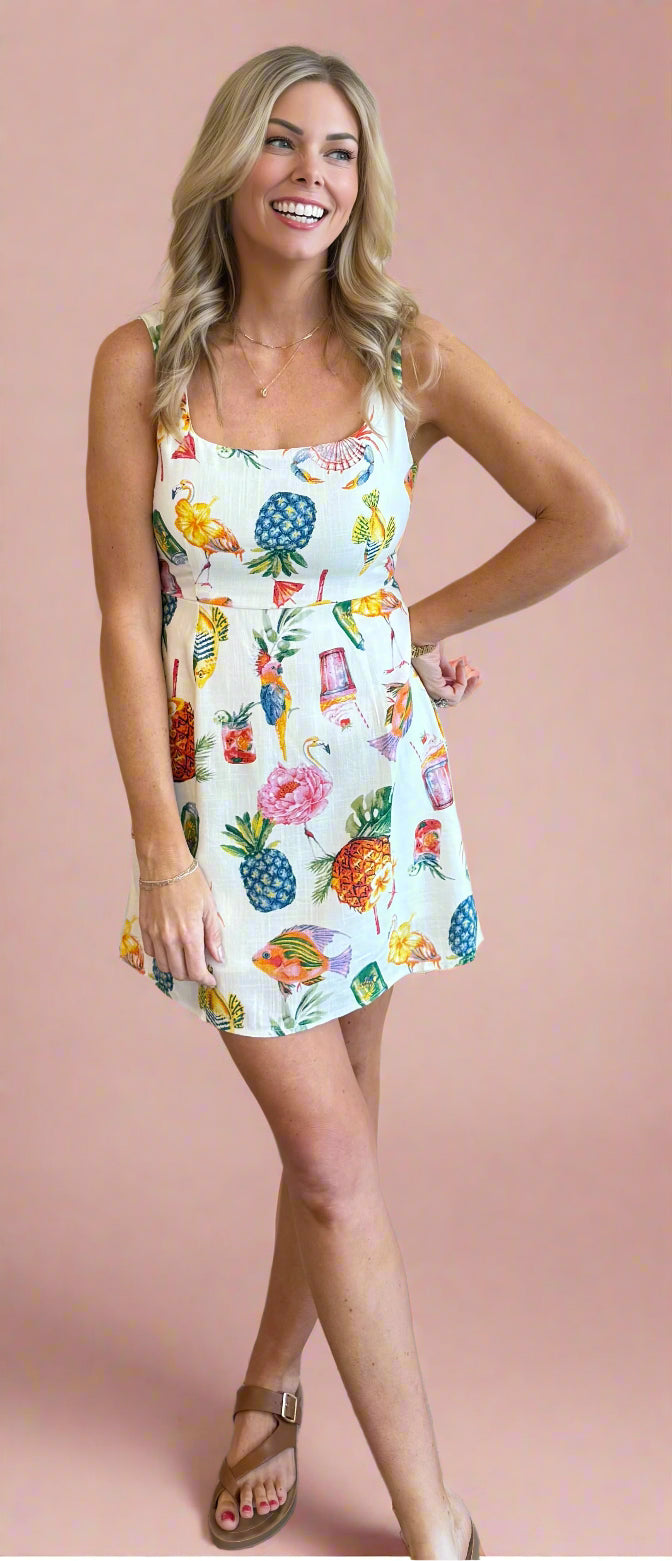 Woman wearing a colorful floral dress against a beige wall.