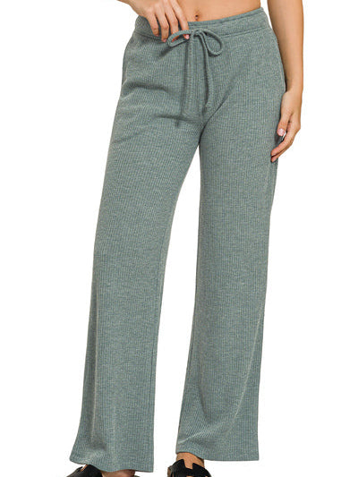 Green ribbed pants worn by a person on a white background