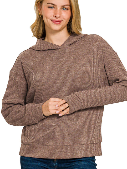 Woman wearing a brown ribbed hoodie on a white background