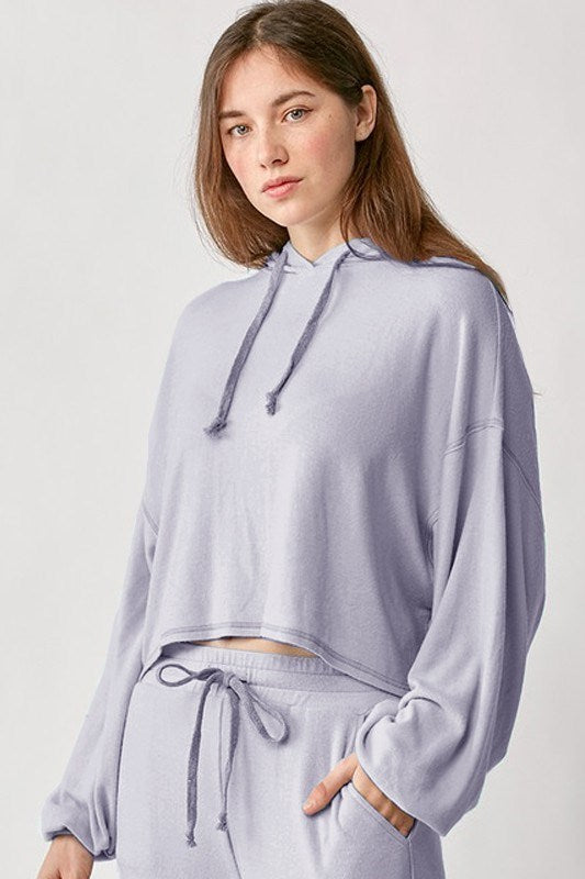 Woman wearing a light purple hoodie and pants on a white background