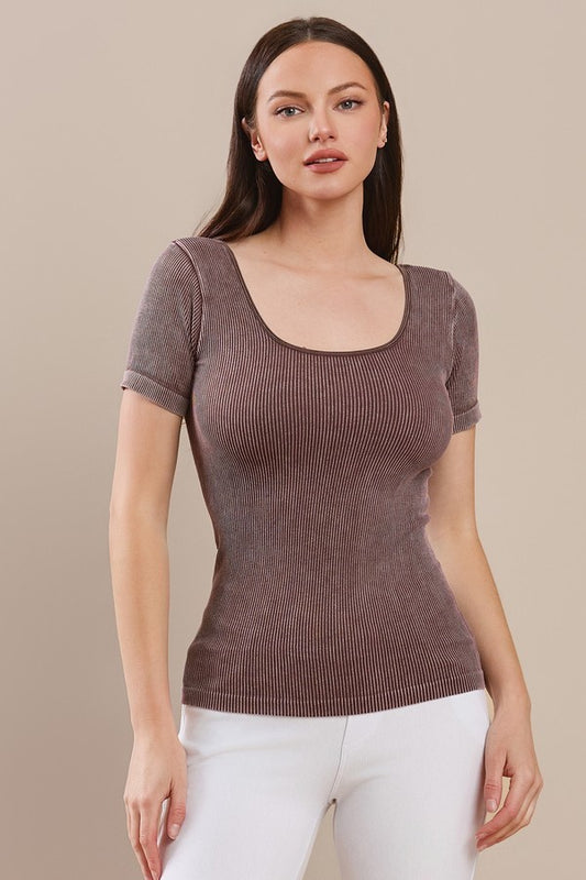 Woman wearing a cocoa colored ribbed knit top against a beige background