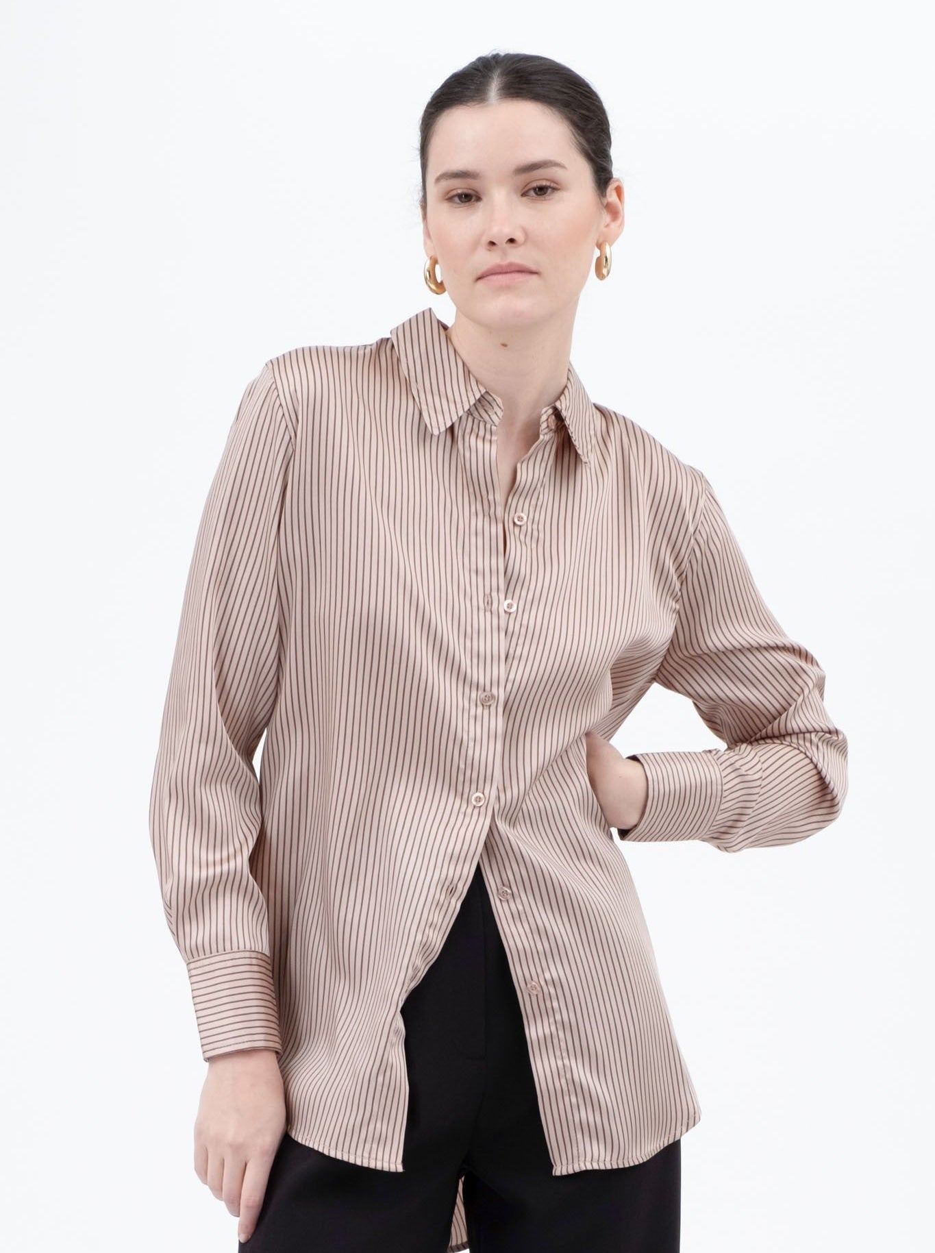 Woman wearing a striped shirt and black pants on a white background
