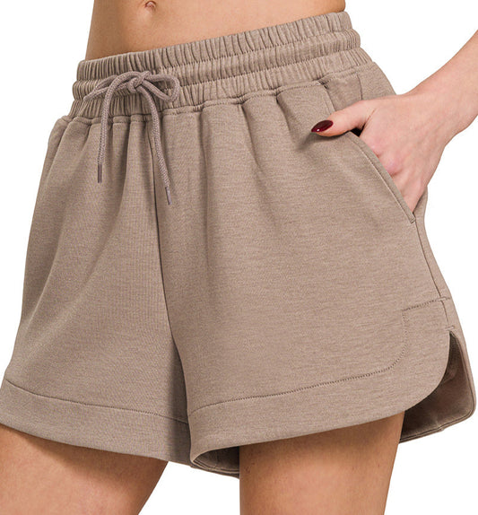 Beige shorts worn by a person on a white background