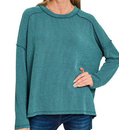 Woman wearing a teal sweater on a white background