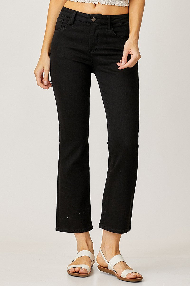 Person wearing black risen jean pants on a plain background