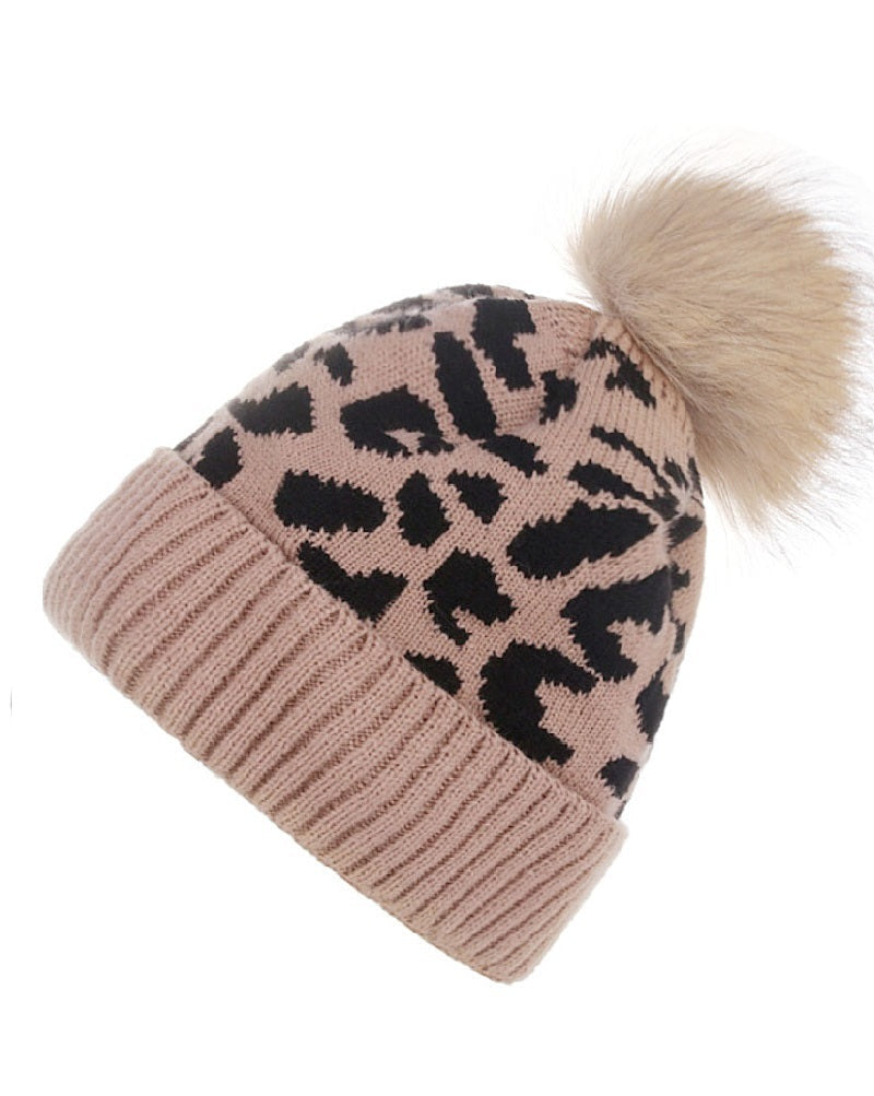 Beige beanie with black leopard print and fur pom-pom on a white background