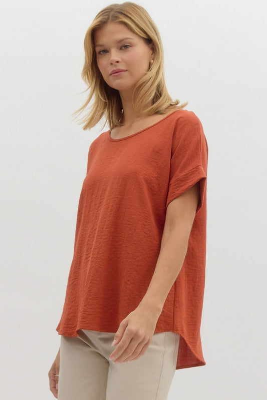 Woman wearing a rust-colored t-shirt on a white background